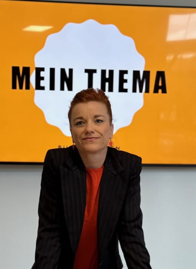 Christiane Schmieder im Seminarraum vor einer Leinwand mit der Aufschrift Mein Thema